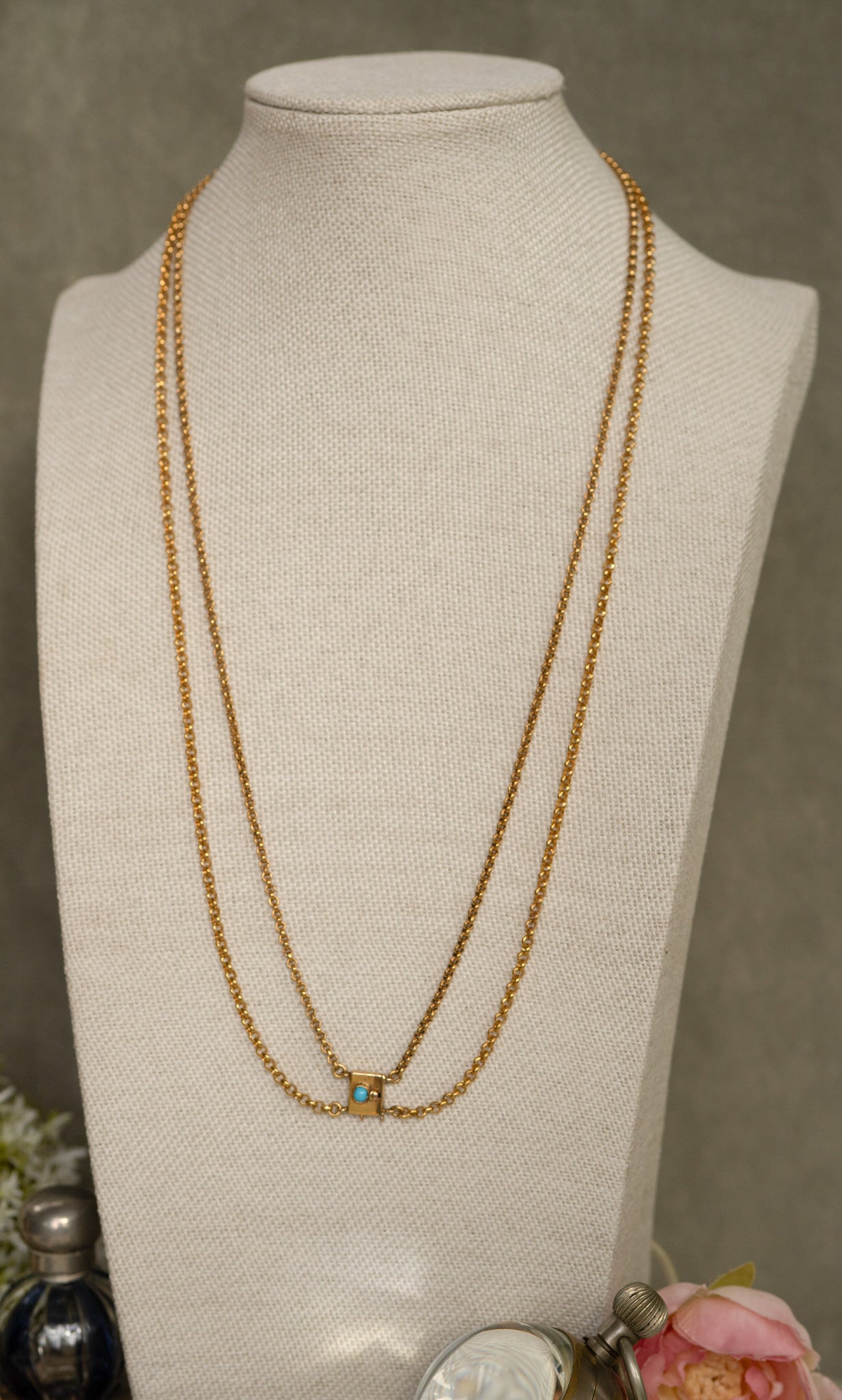 Gold necklace on a mannequin bust with a neutral background